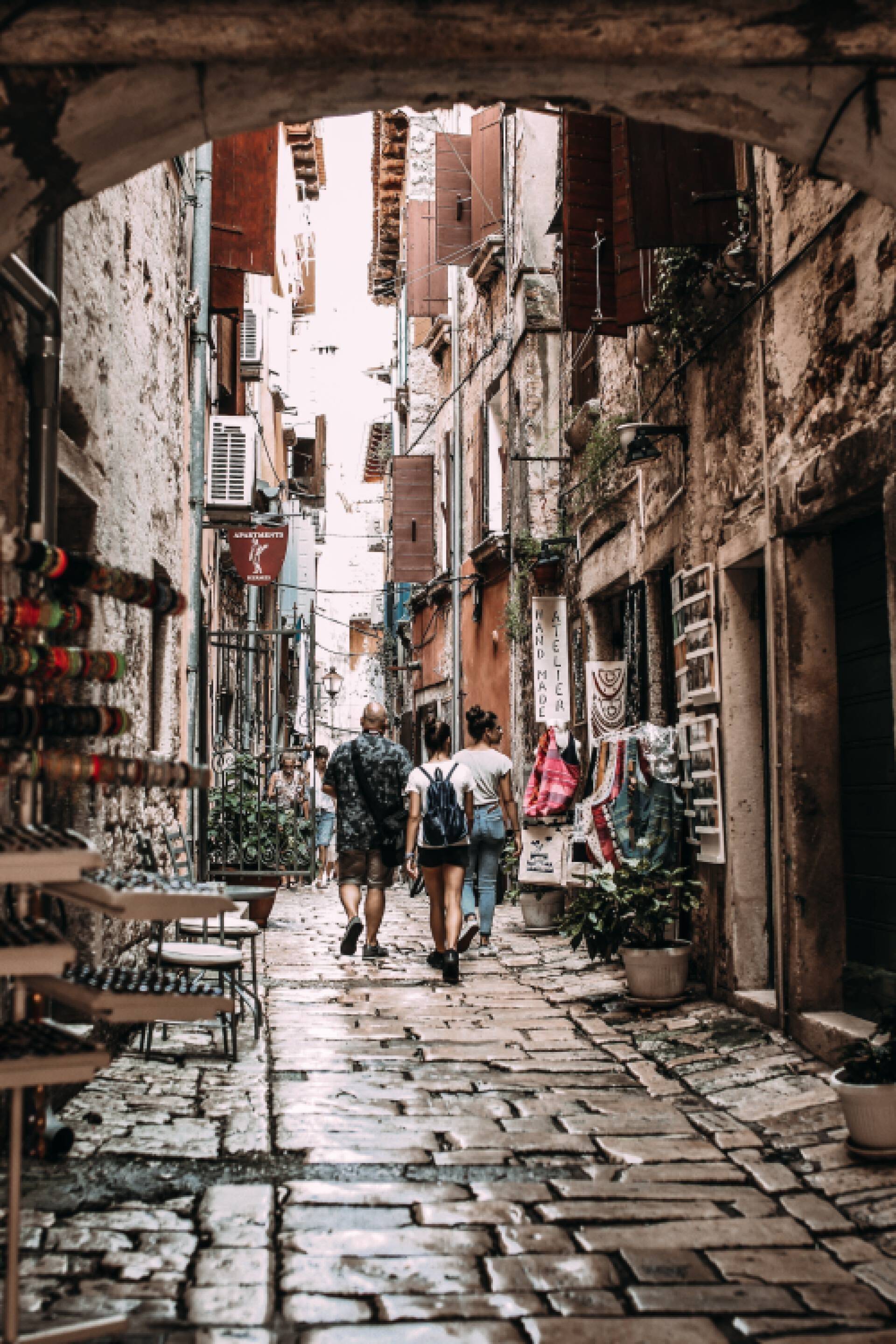 Cobble stone alley with people walking away from the viewer
